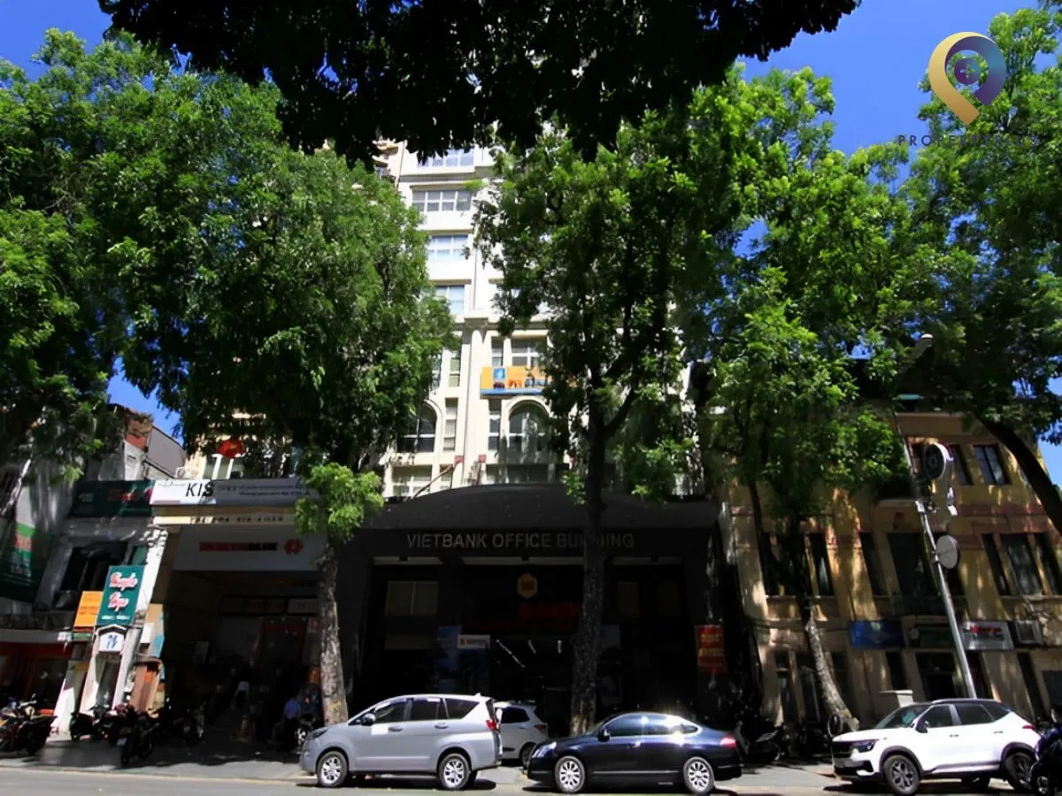 Tòa nhà Vietbank Building nhìn từ mặt đường với hàng cây lớn phía trước.